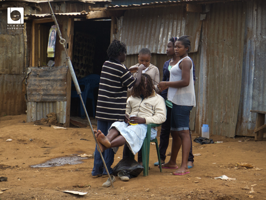 キベラの片隅で。女性が髪を編んでいた